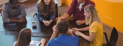 Business executives interacting with each other while having coffee in office